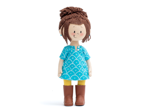 Mini Ava Handmade Cultural Doll in her blue long shirt, yellow pants and brown boots showing the doll from the front angle