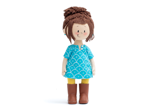 Mini Ava Handmade Cultural Doll in her blue long shirt, yellow pants and brown boots showing the doll from the front angle